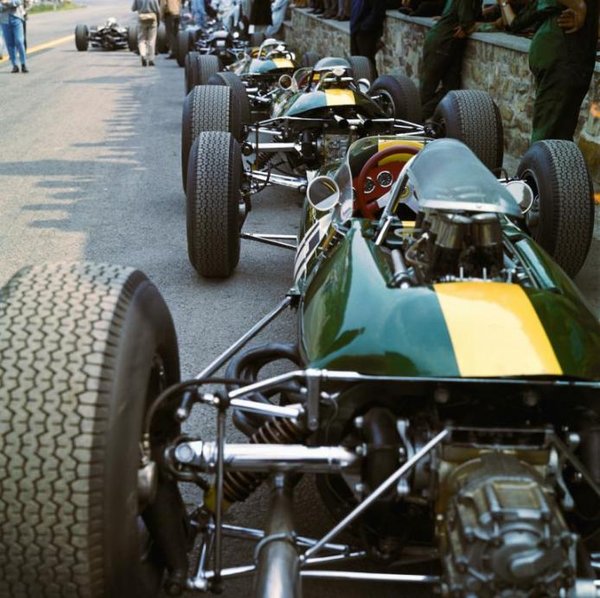 1965 Belgium Spa - The three Lotus cars of Clark and Spence stringed together in pits at Spa-Francorchamps. Later winner Clark uses the Lotus 25 (2nd car in the line with upper exhausts) during practice only.jpg